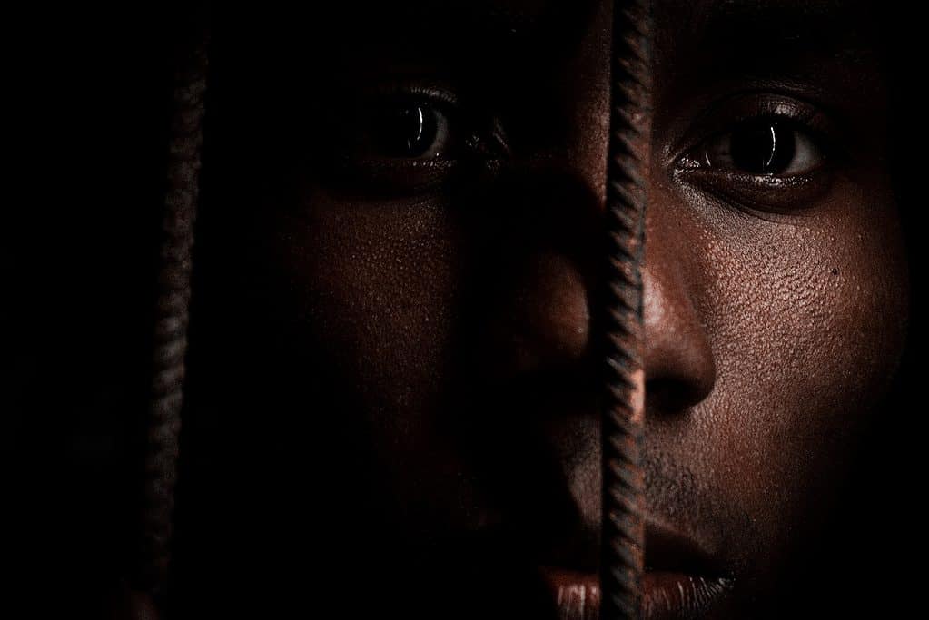 Black man behind slave steel bars