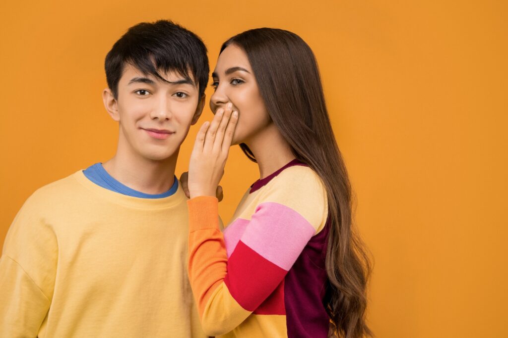 Woman whispering to man